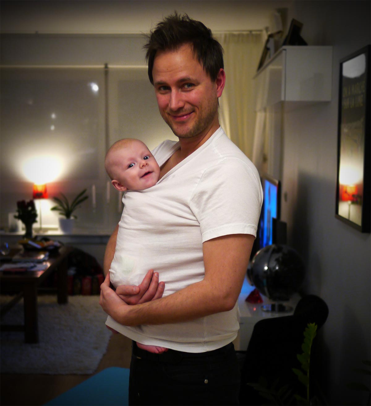 Elis som bebis, i pappas tröja med huvudet uppstickande i halslinningen.