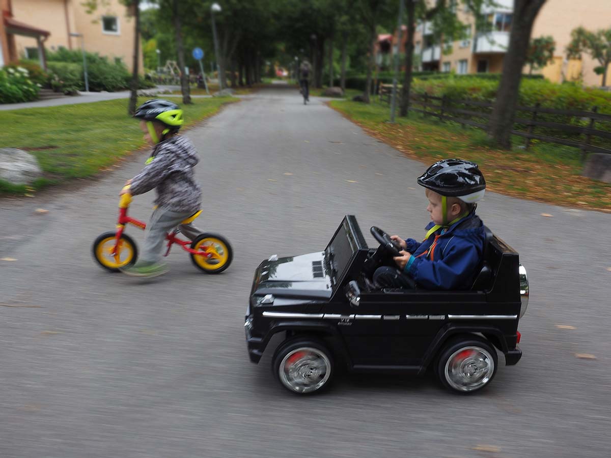 Folke och Elis på utflykt med springcykel och elbil.