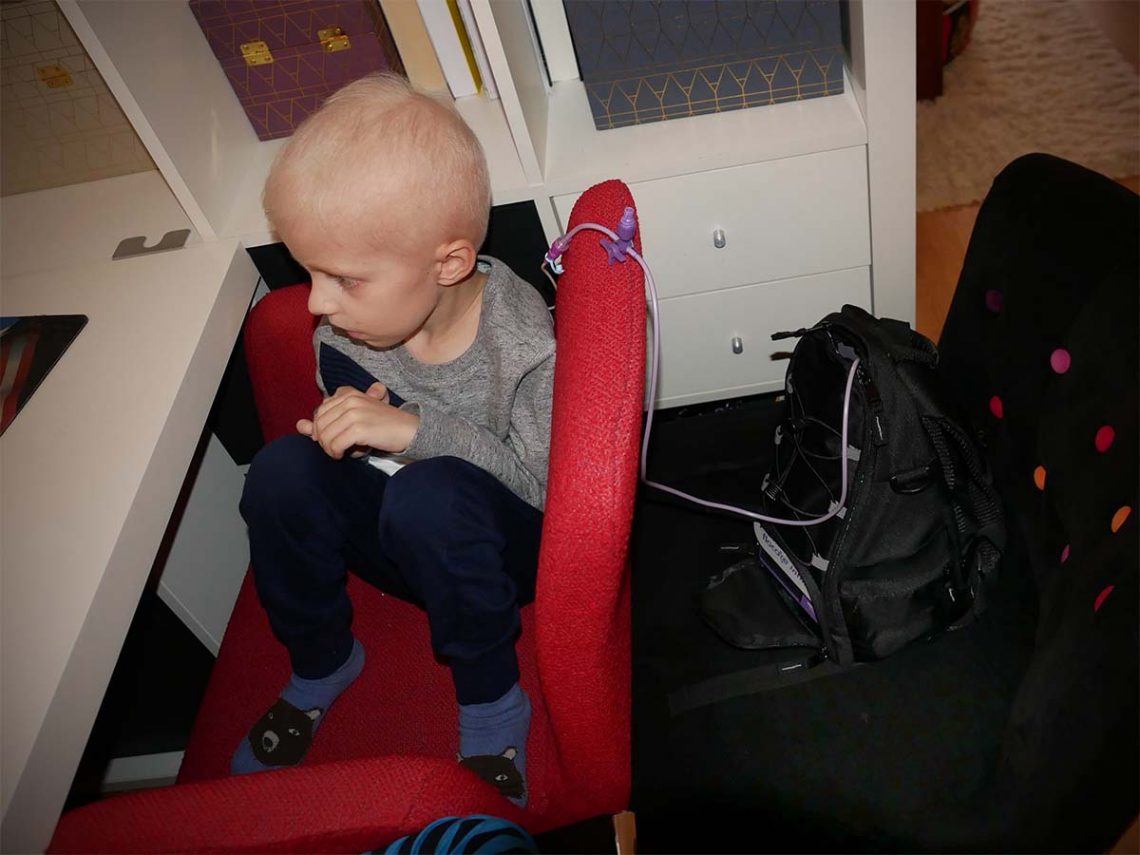 Elis ser på datorn med sin sond och pumpryggsäck