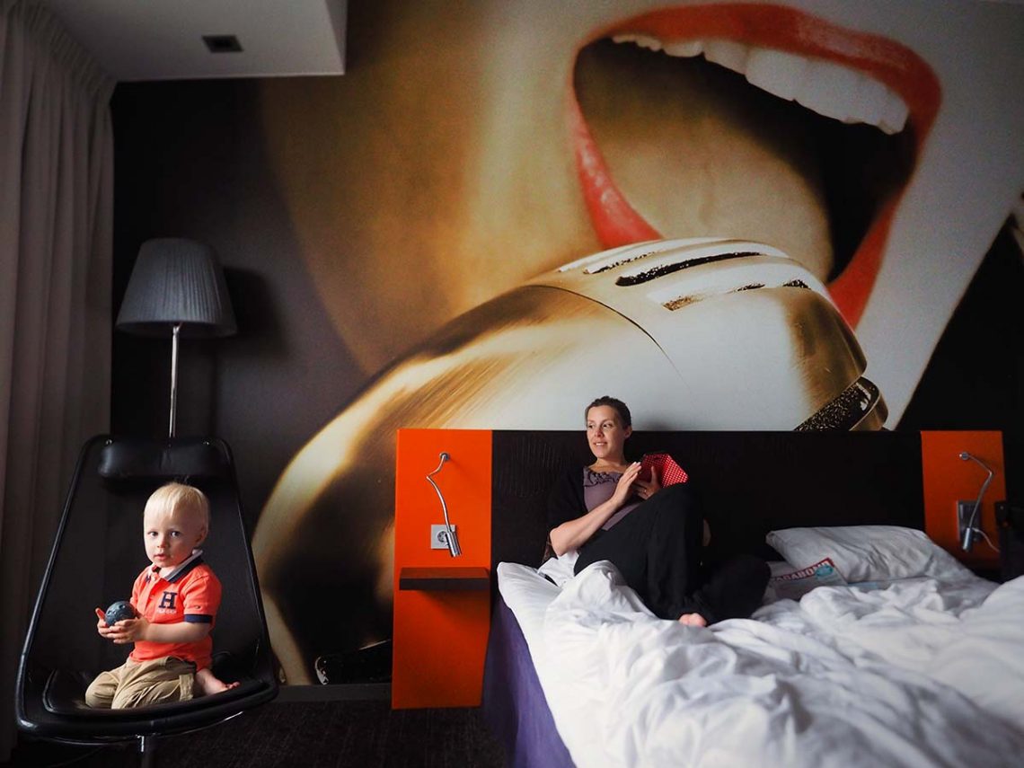 Elis och Sandra på ett hotellrum med fondvägg.