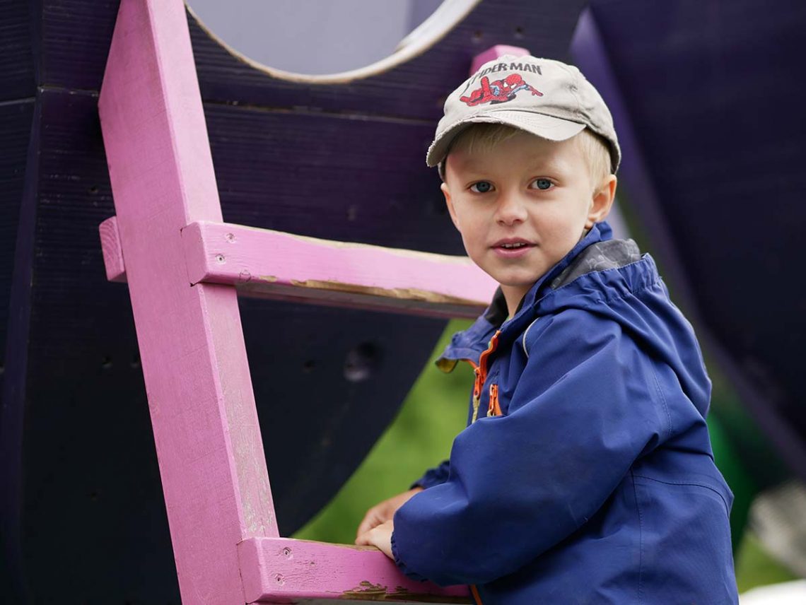 Elis klättrar uppför en stege i en lekpark.