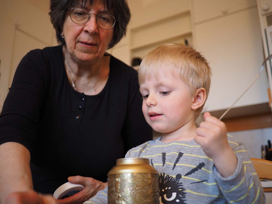 Farmor och Elis i köket med en teburk.