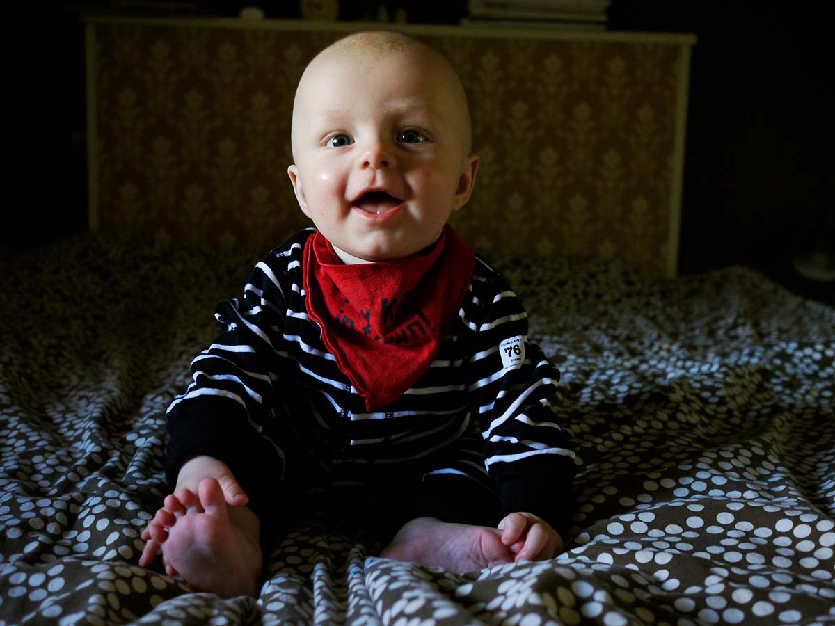 Elis sitter i sängen, 7 månader
