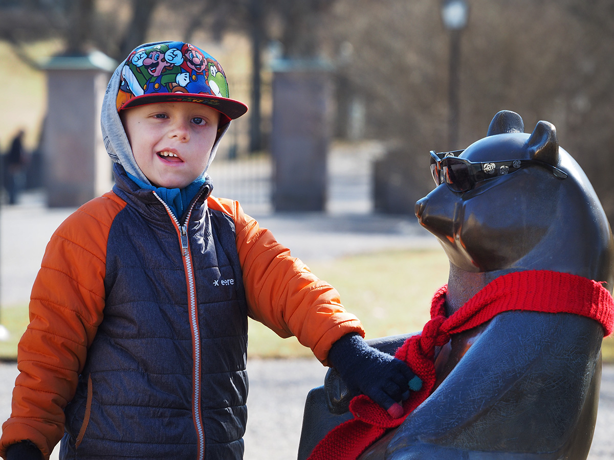 Elis skrattar åt att någon dekorerat björnstatyn i slottsparken