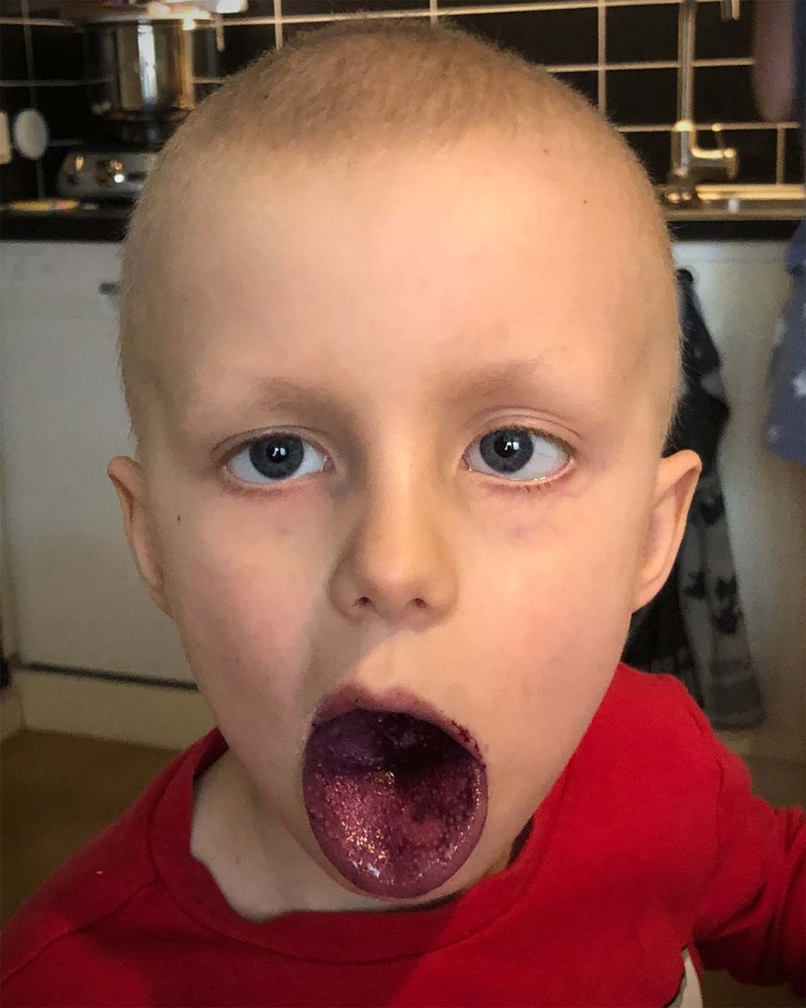 Elis visar sin blåbärstunga under frukosten