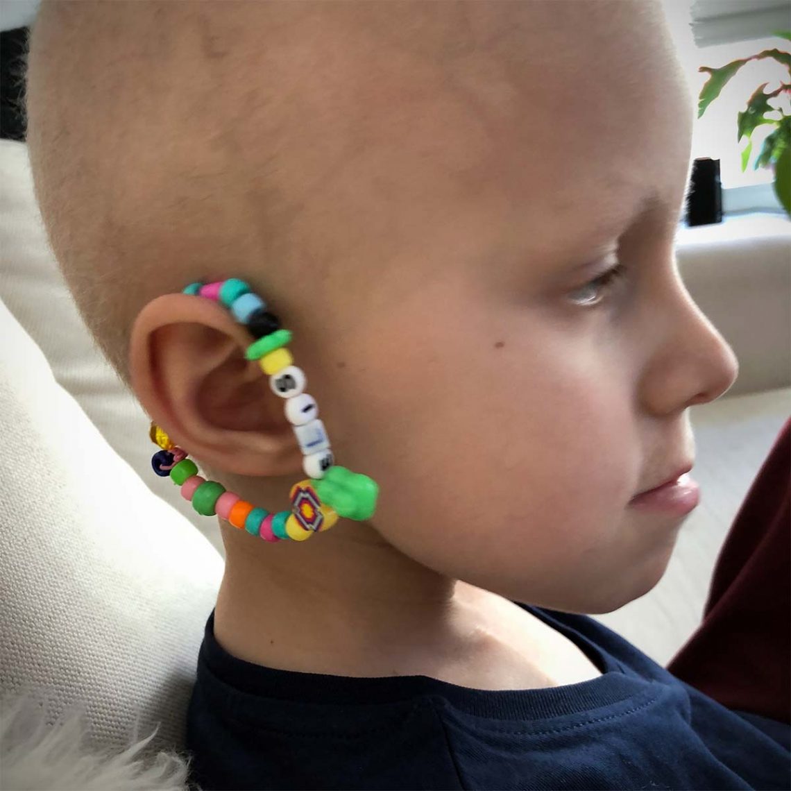 Elis har gjort ett armband med sitt namn, och hängt det på örat