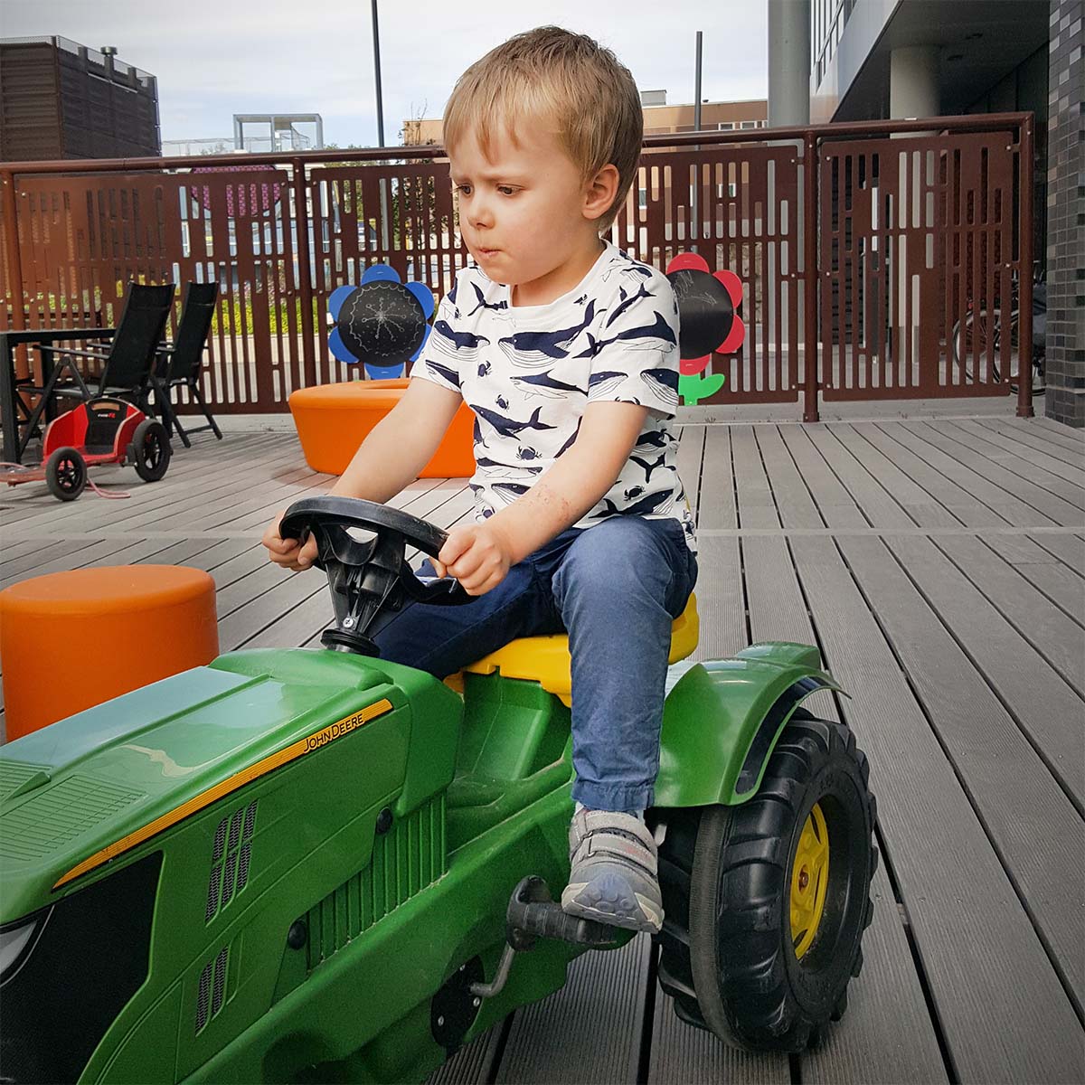 Folke kör traktor på lekterapins uteplats