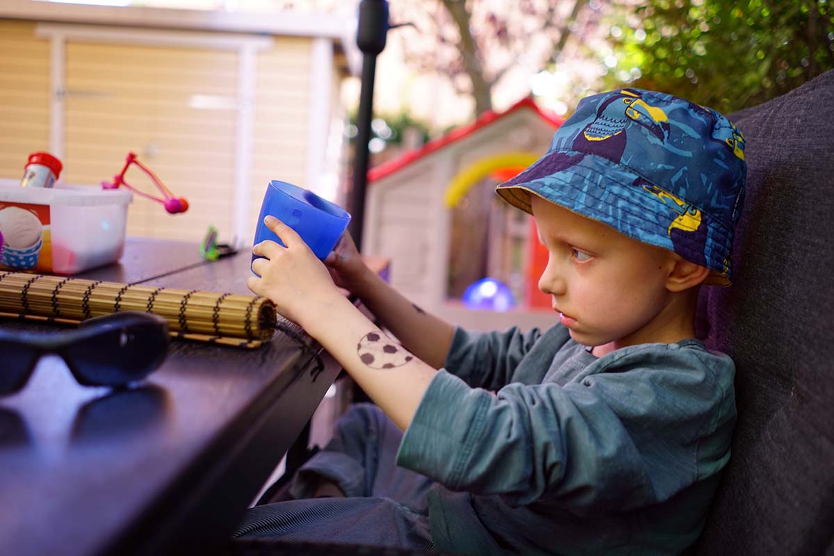 Elis sitter vid matbordet på uteplatsen