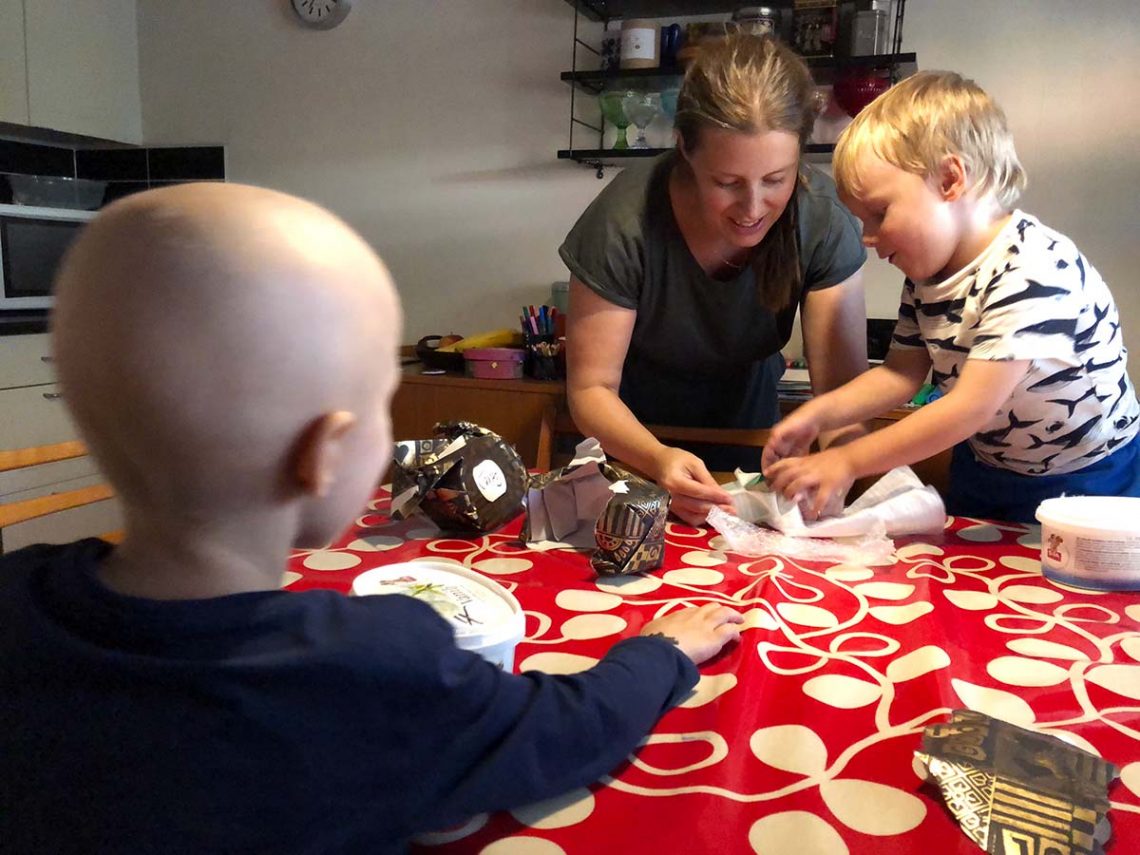 Elis, mamma och Folke på väg att öppna presenter från farmor
