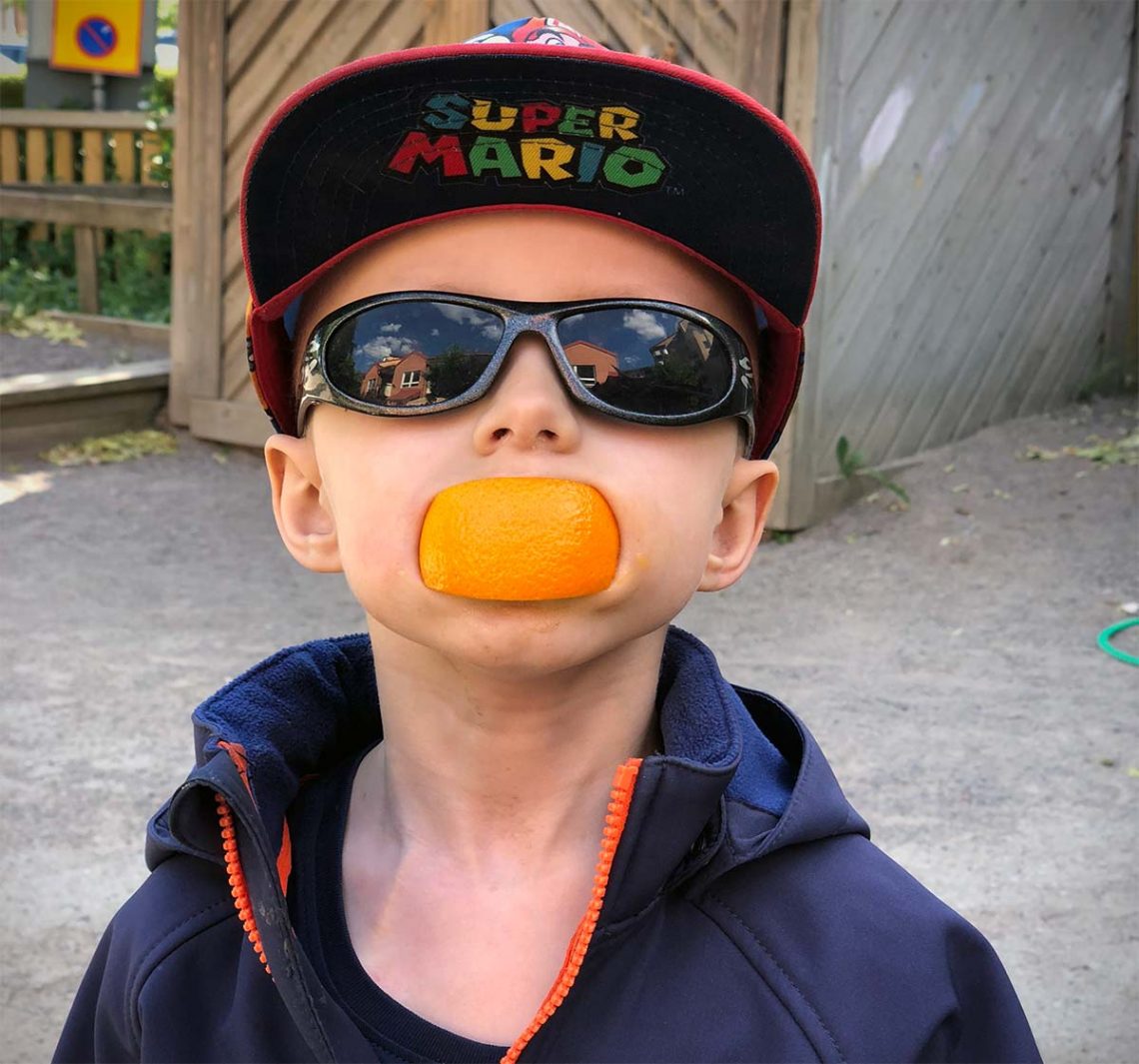 Elis busar med ett apelsinskal i munnen