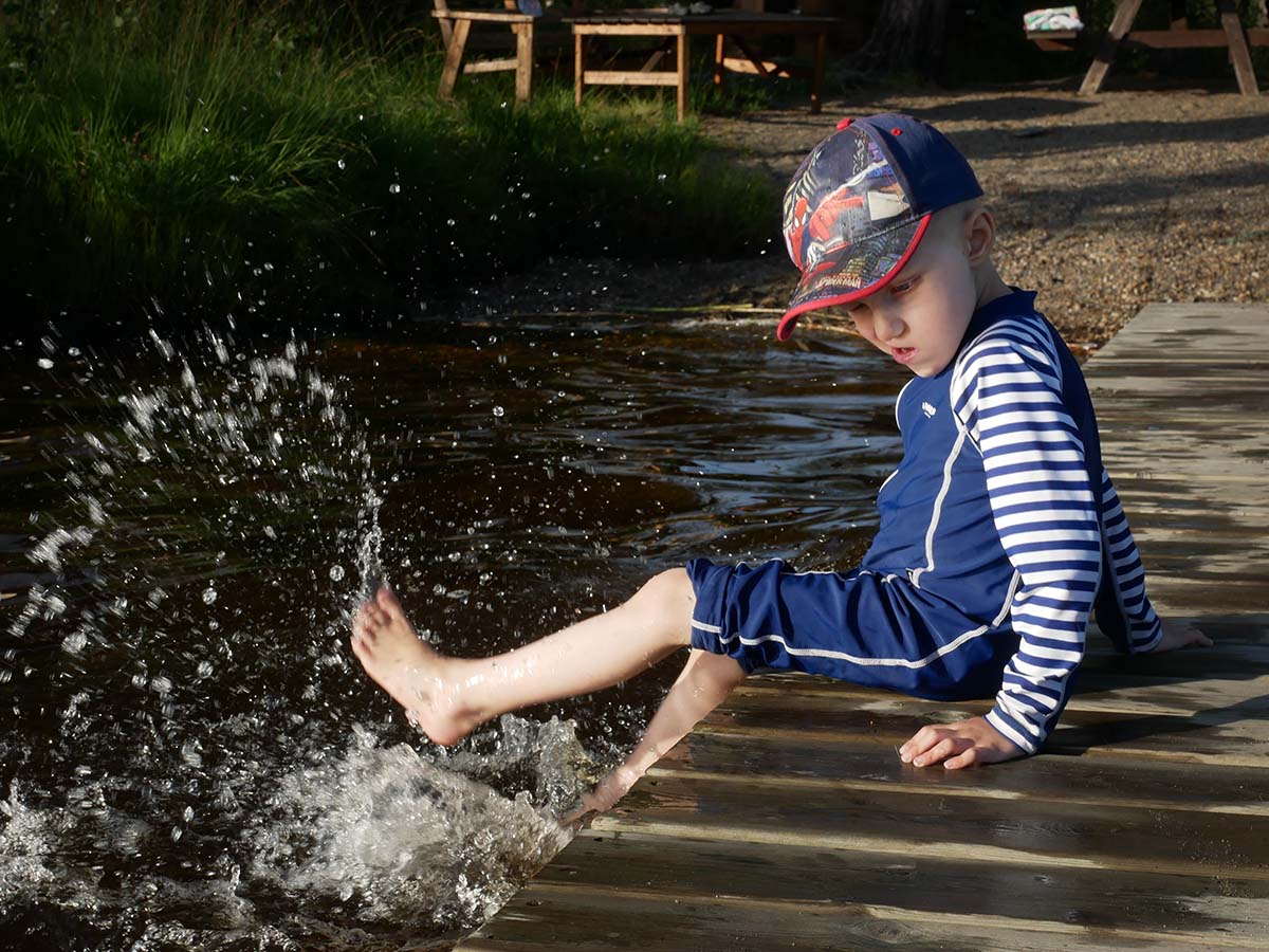 Elis plaskar med benen från bryggan