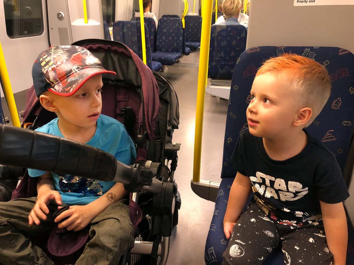 Elis och Folke på tunnelbanan efter att Folke klippt sig och fått orange hår