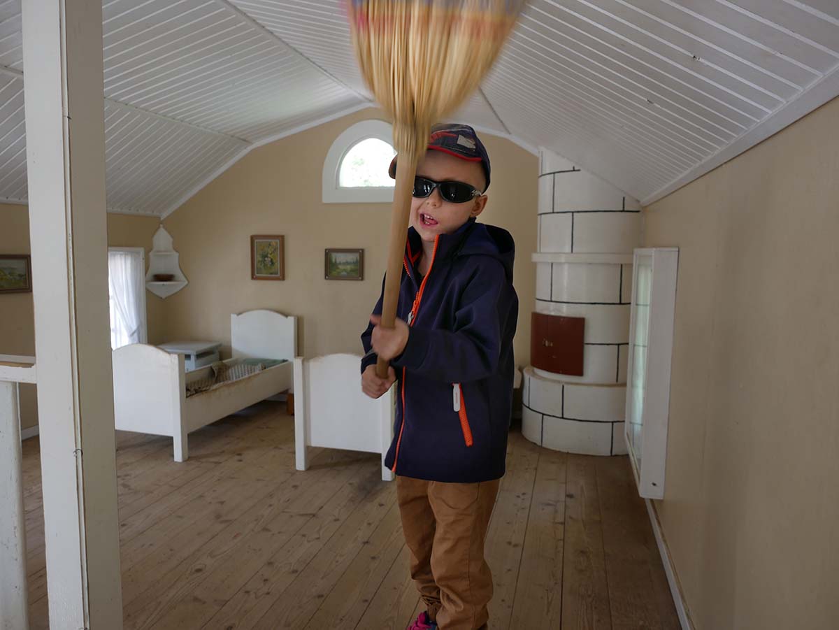 Elis viftar med en kvast inne i ett minihus