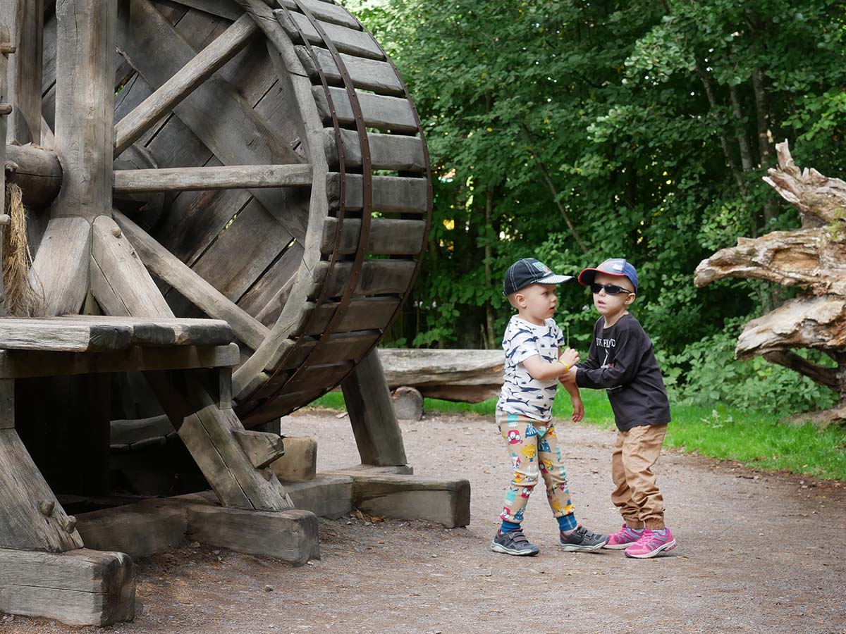 Folke och Elis busar vid ett stort trähjul