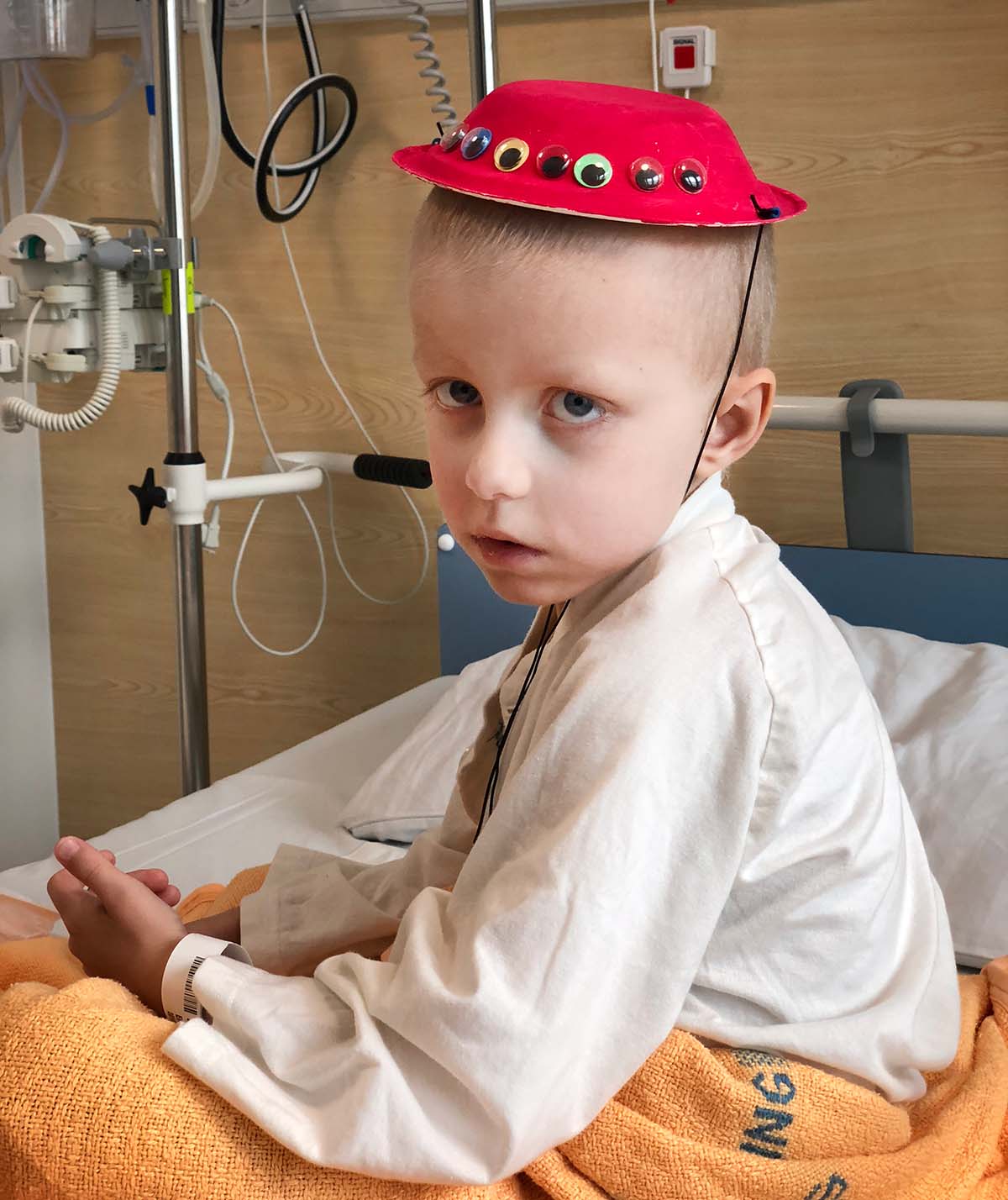 Elis i en röd hatt som han gjort på lekterapin av en papptallrik