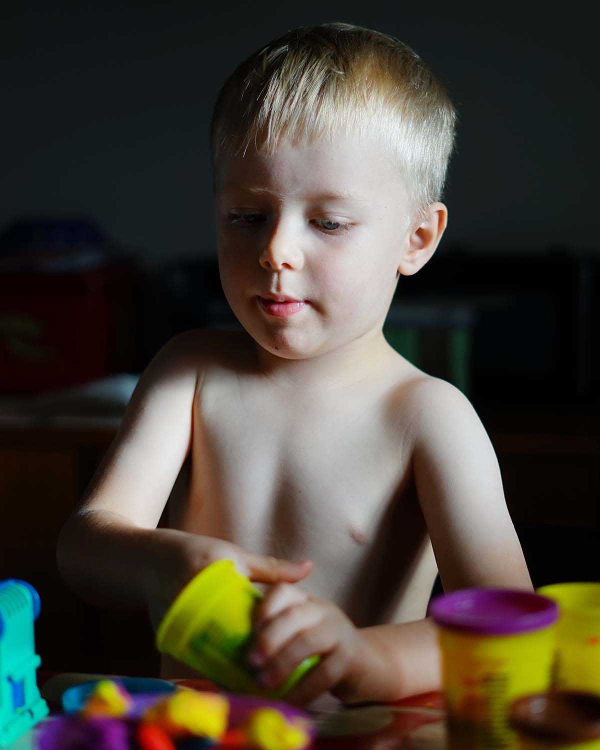Folke leker med Play-Doh vid köksbordet