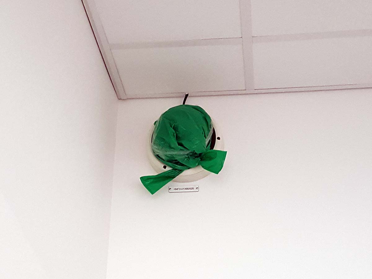 Övervakningskamera på Nya Karolinska täckt av grön plast