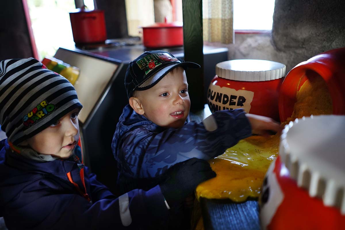 Elis och Folke inspekterar honungsburkar inne hos Bamse