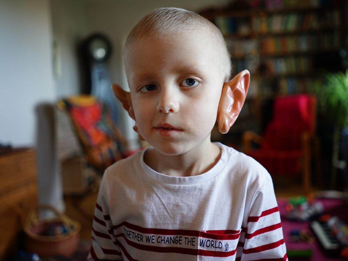 Elis är hos farmor och har satt på sig ett par jättestora öron av plast