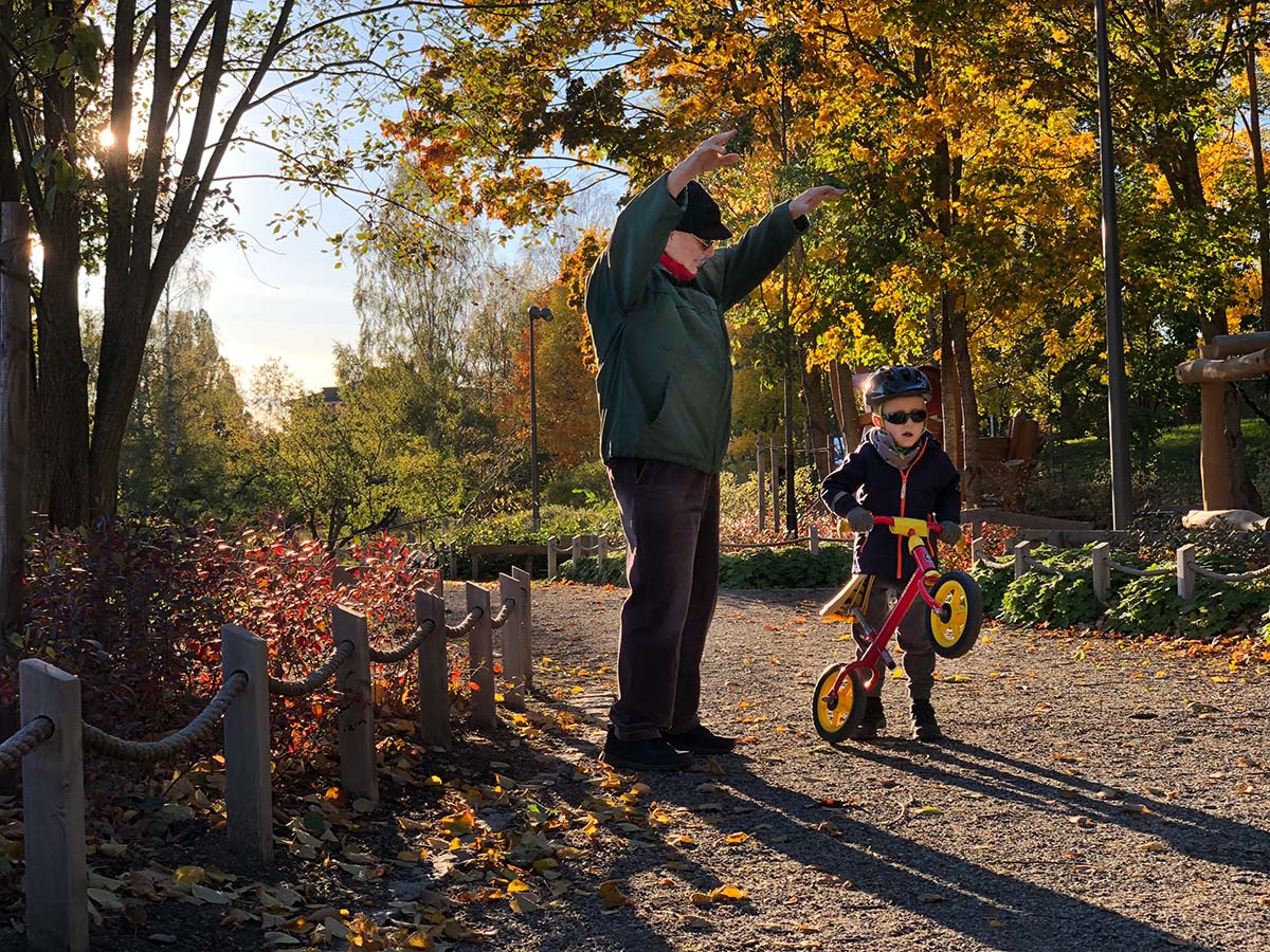 Farfar och Elis, med springcykel, ute i lekparken