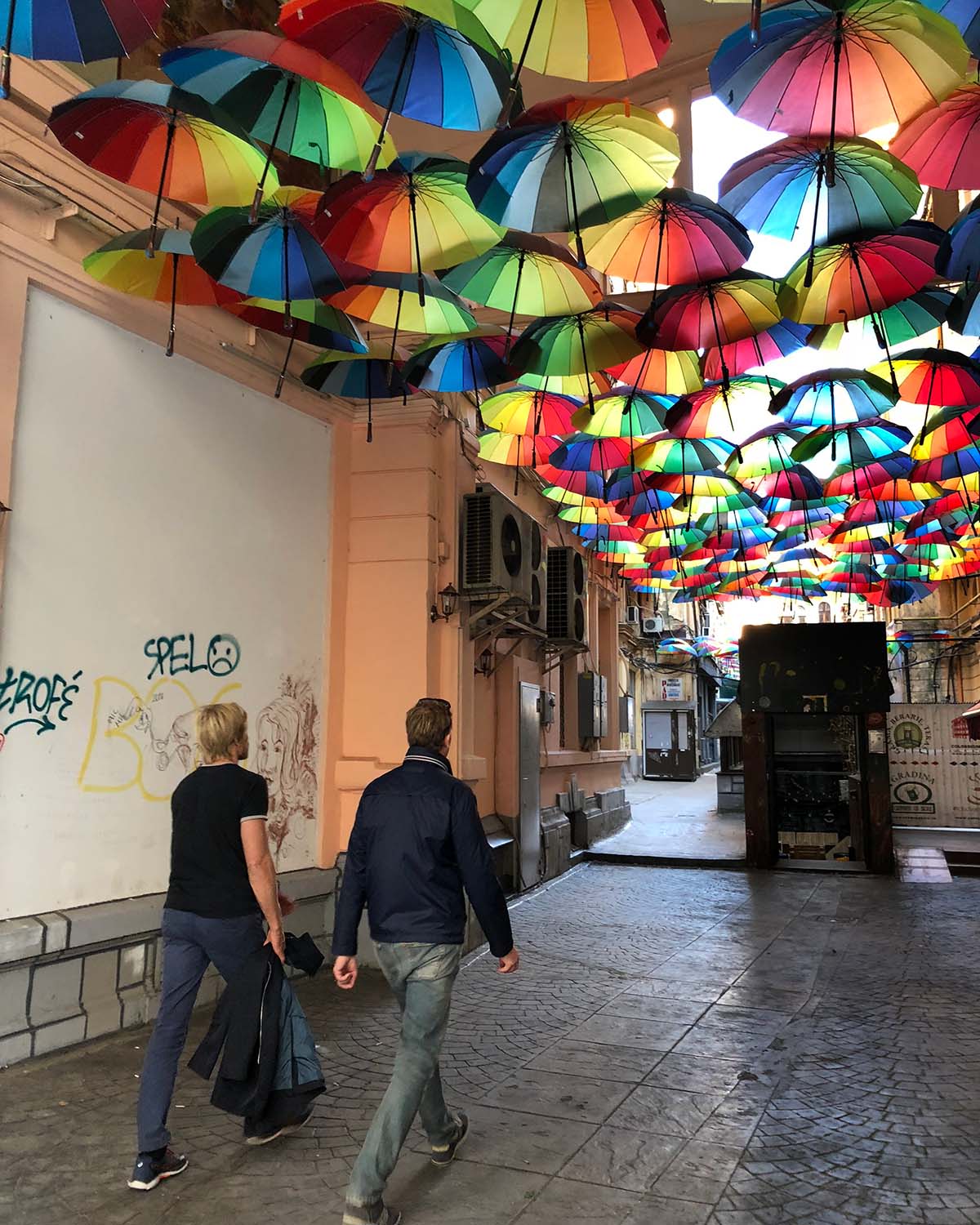 Färgglada paraplyer i en gränd i Bukarest