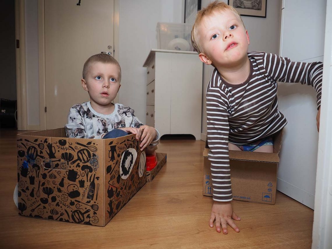 Elis och Folke leker i kartonger som föreställer bilar