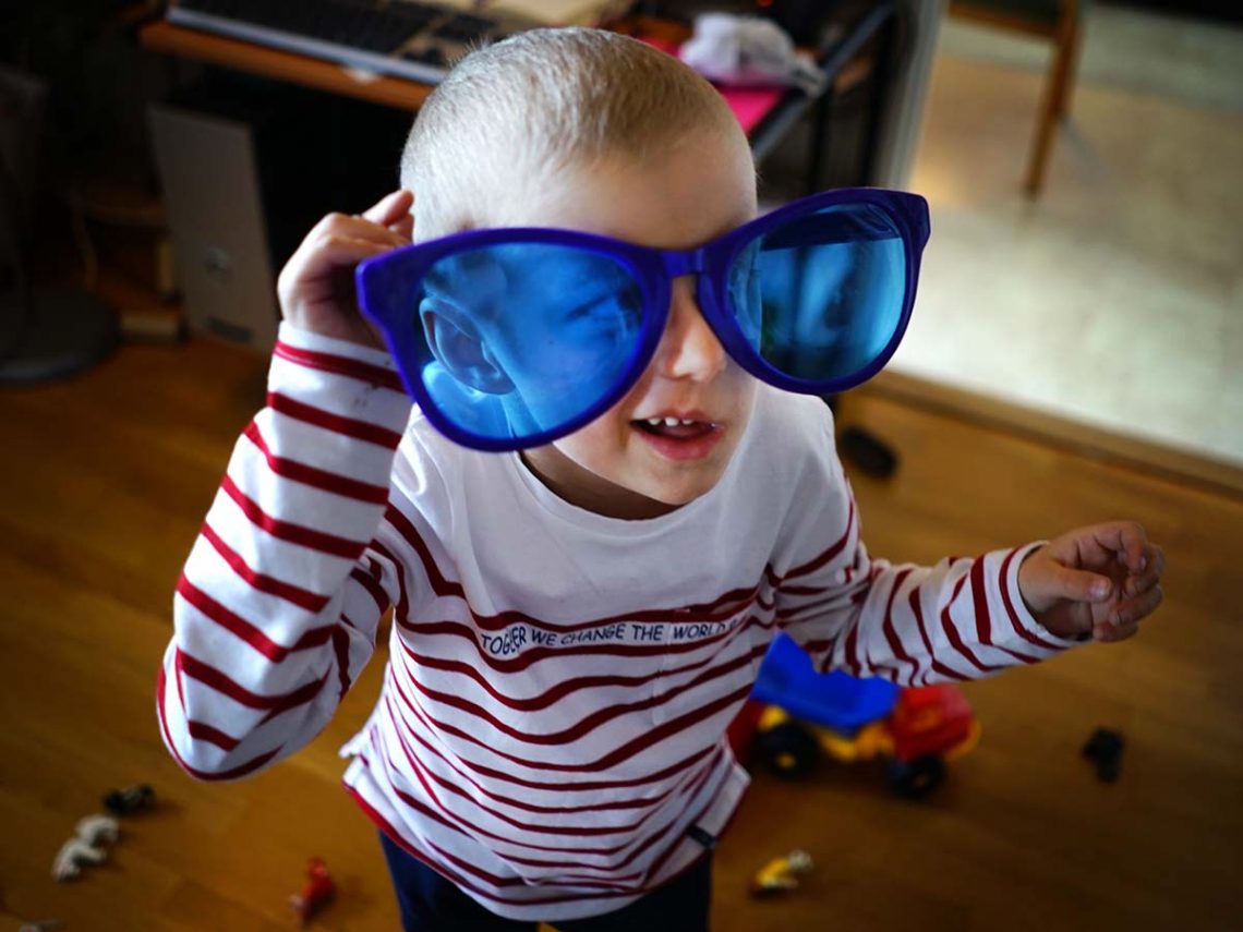 Elis hos farmor, iklädd roliga blå jättesolglasögon