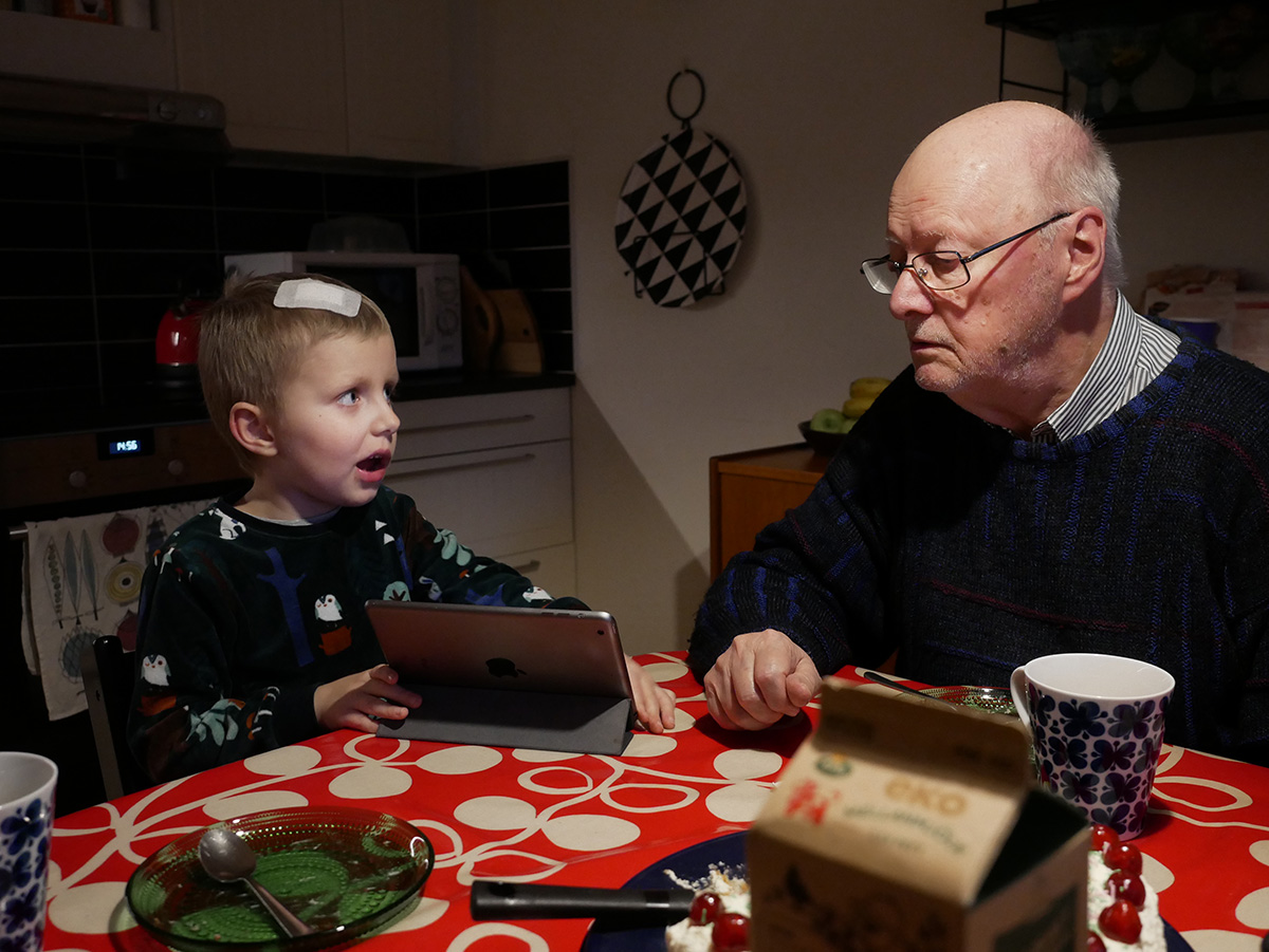Elis visar en app på iPaden för farfar