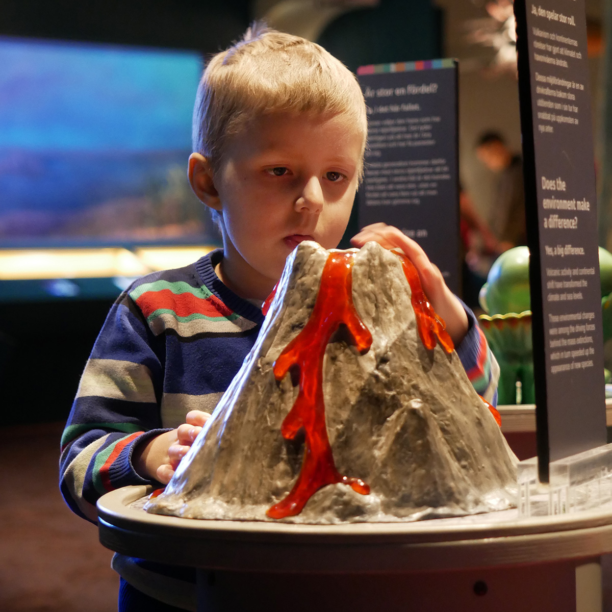 Elis framför en vulkanmodell på Naturhistoriska Riksmuséet