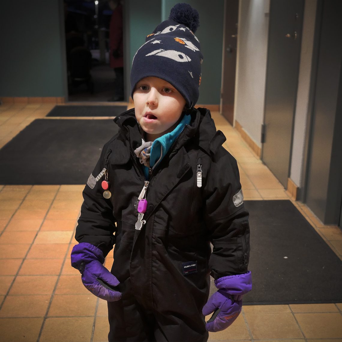 Elis vinterklädd väntar hemma i trapphuset