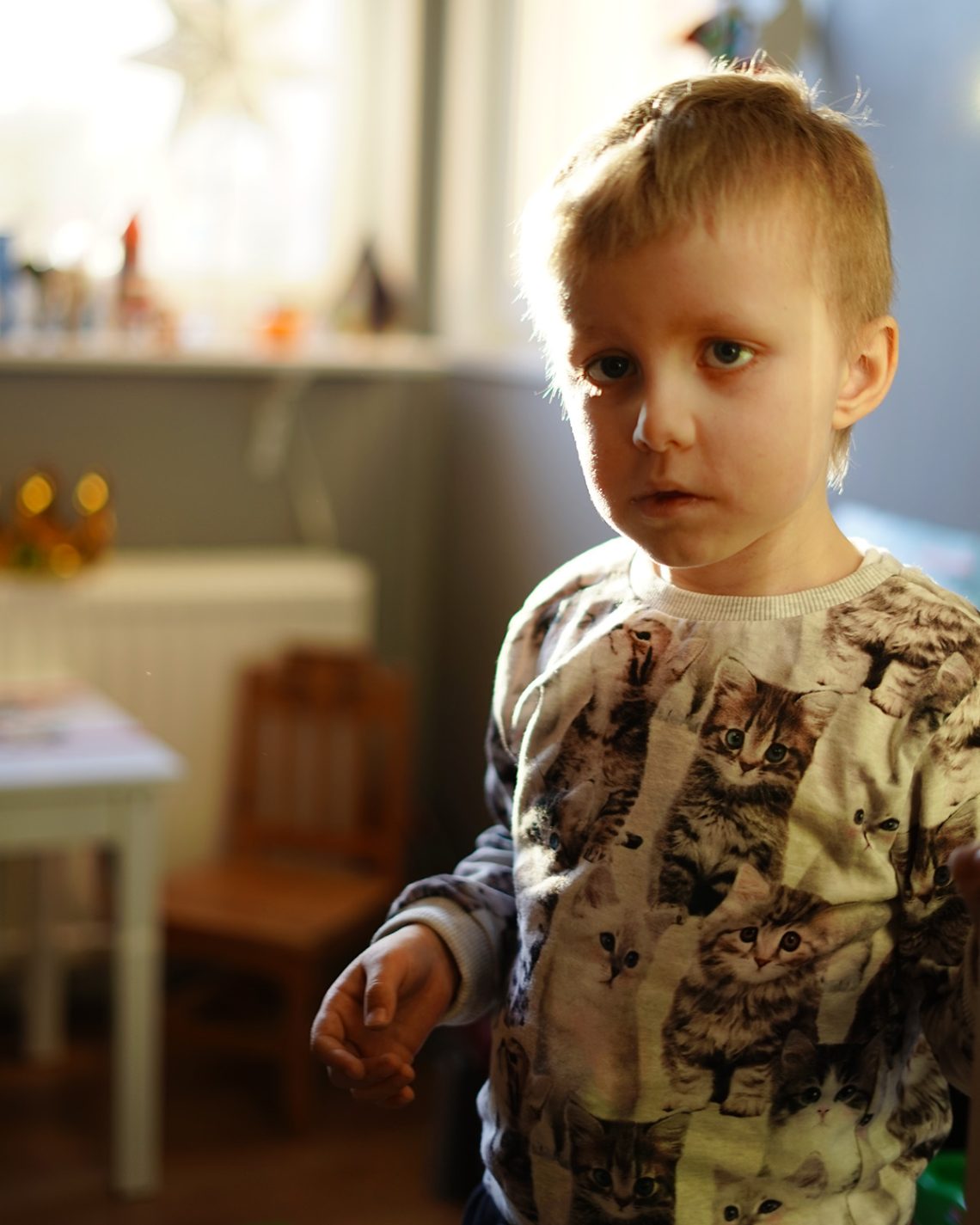 Elis i sitt rum, iklädd en tröja med katter på