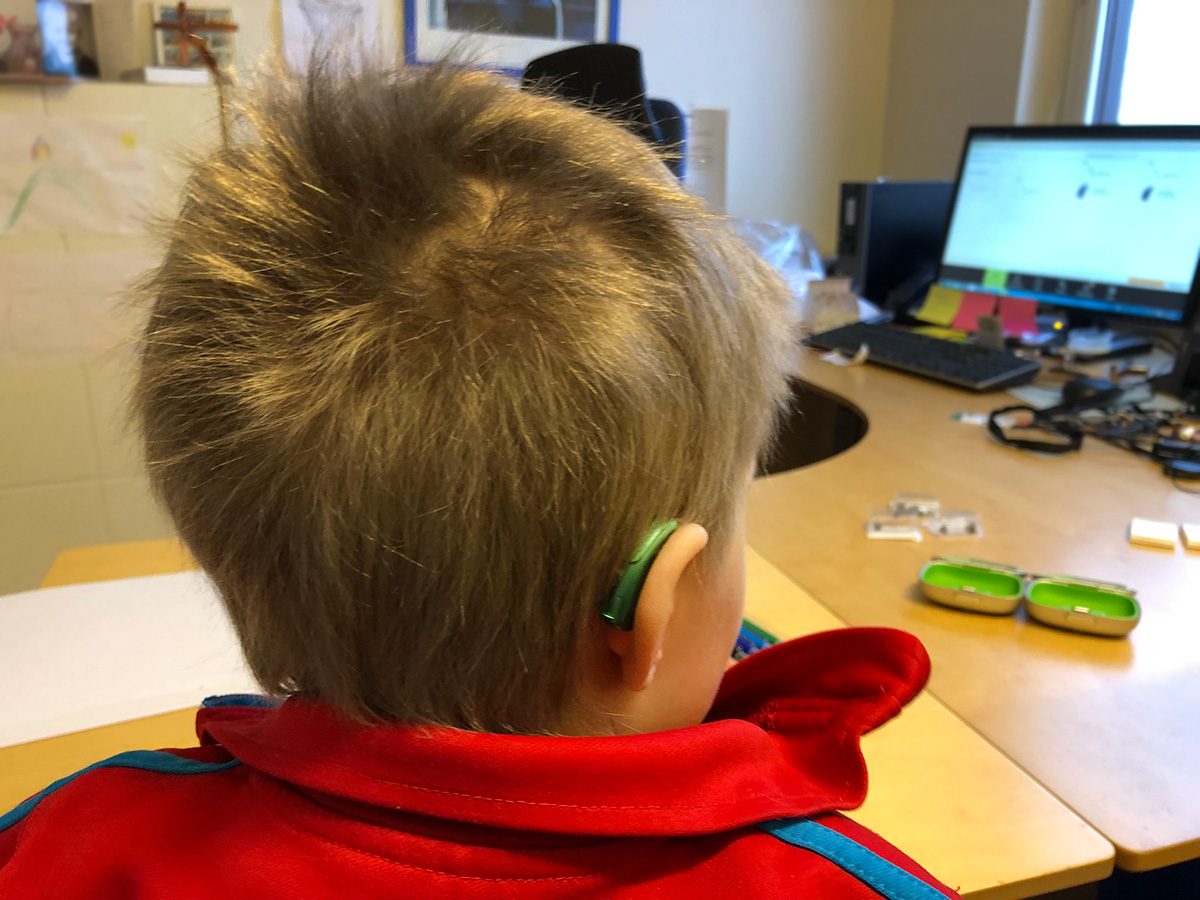 Elis har fått på sig hörapparaten, som sitter diskret bakom örat.