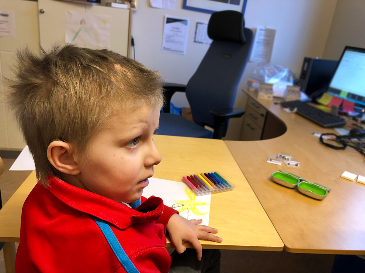 Elis hos audionomen, med den nya hörapparaten i örat.