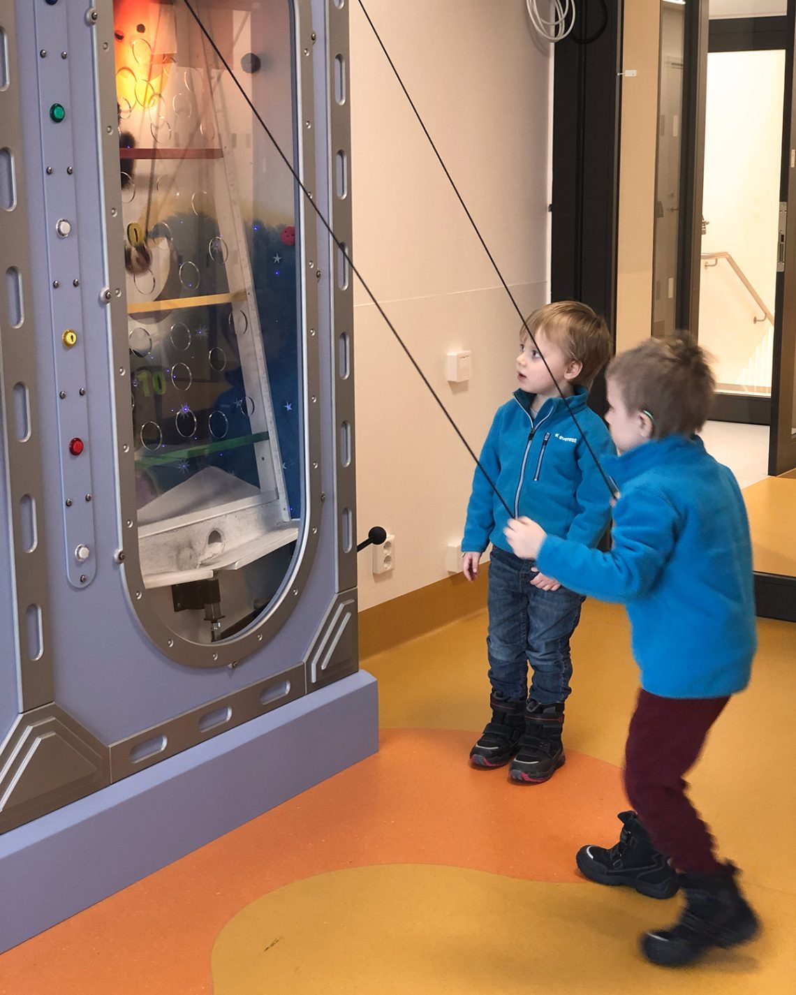 Folke och Elis testar en ny kulbana på avdelningens lekrum, där man drar i snören för att balansera en kula uppåt i banan