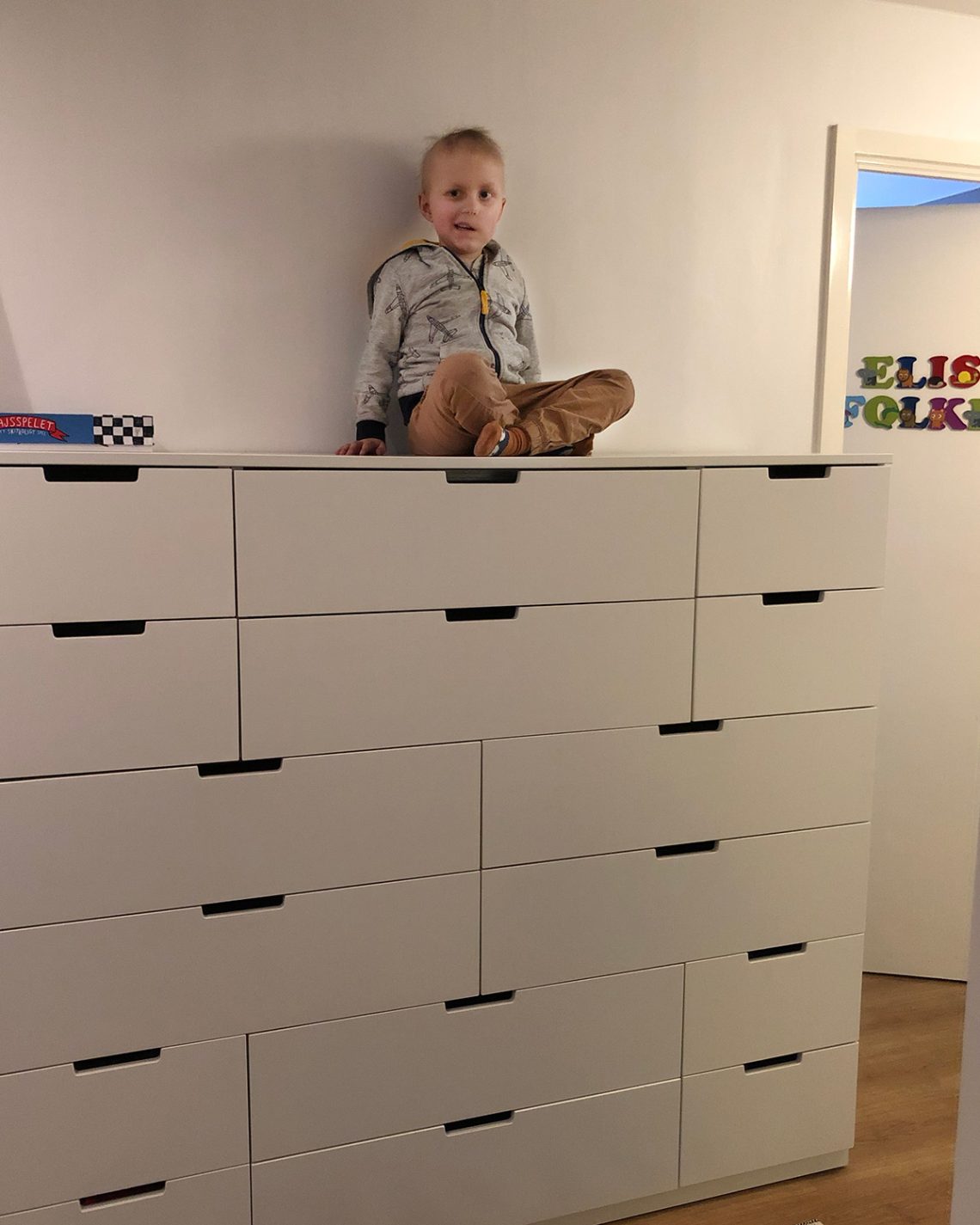 Elis sitter uppe på vår nya höga byrå.