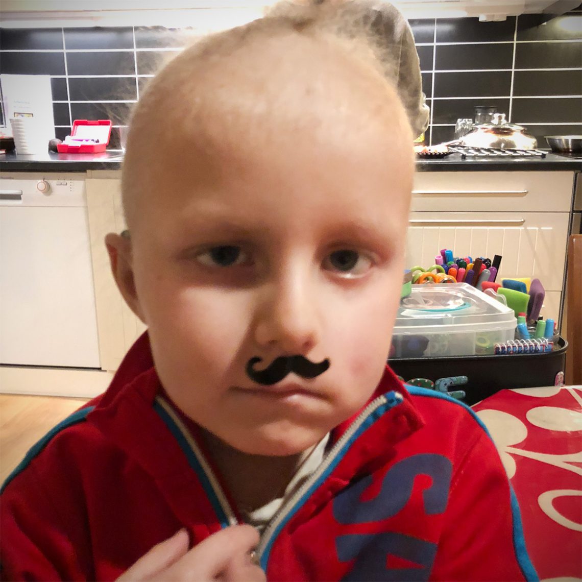 Elis med ett mustaschformat klistermärke på överläppen.