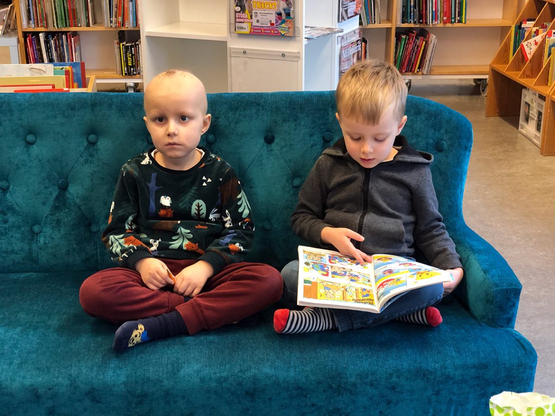 Elis och Folke i en soffa på Bergshamra bibliotek.