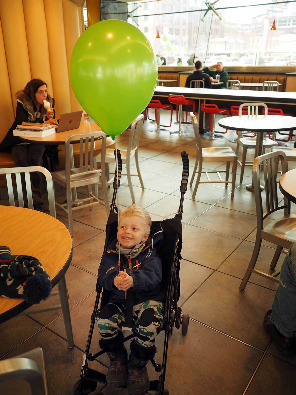 Elis på en hamburgerrestaurang i Chicago, med en stor grön ballong i handen