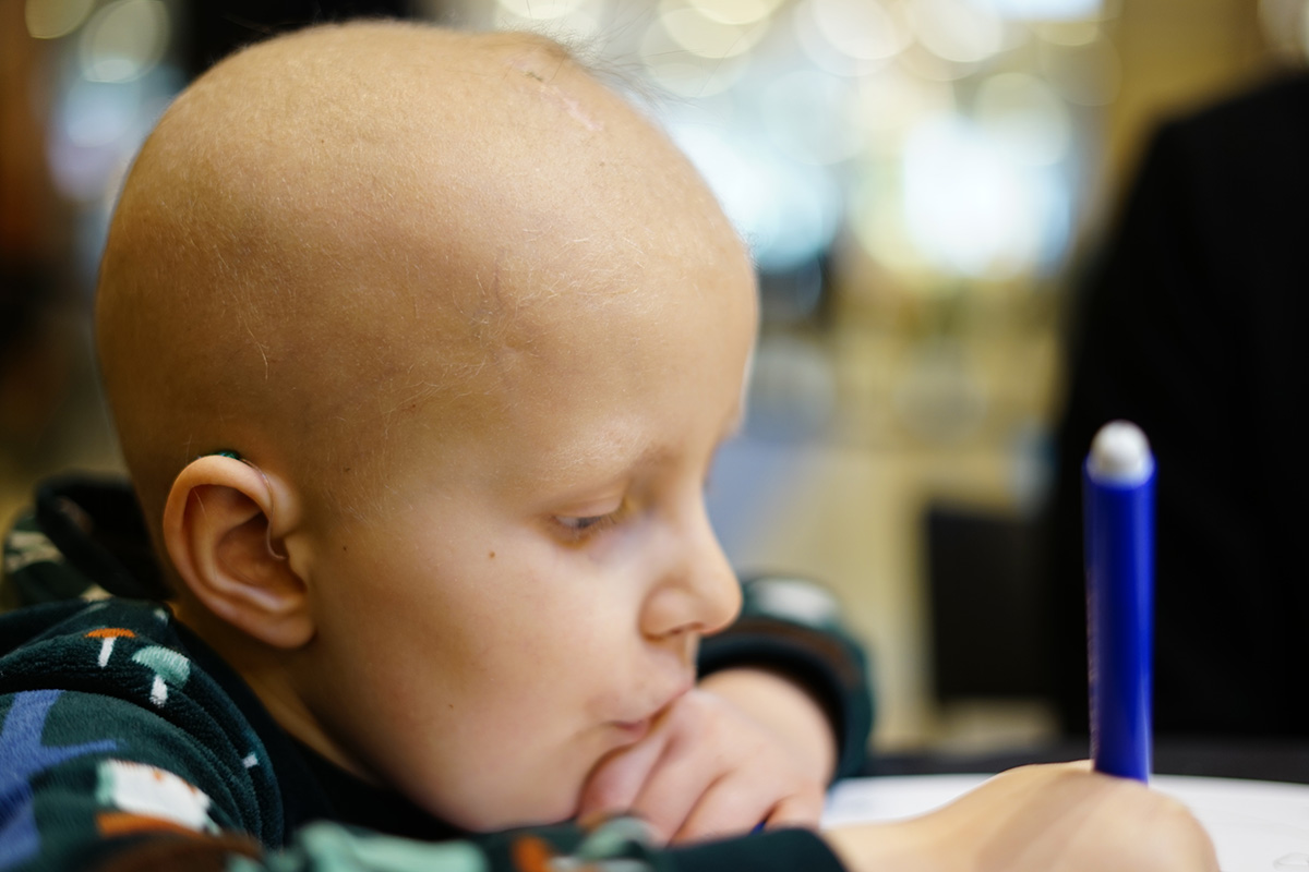 Elis pysslar med en blå penna i handen