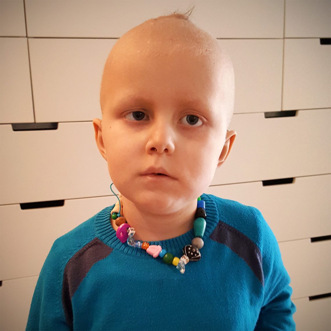Elis med ett egenpysslat halsband på sig.