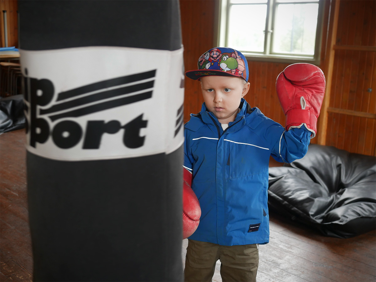 Elis testar boxhandskar och sandsäck uppe i gympasalen på Avaträsks gamla skola