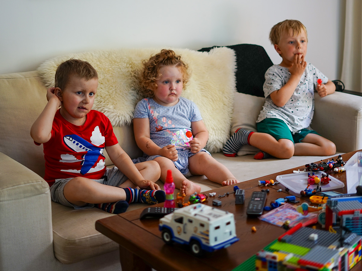 Elis, Saga och Folke tittar på tv och äter lördagsgodis