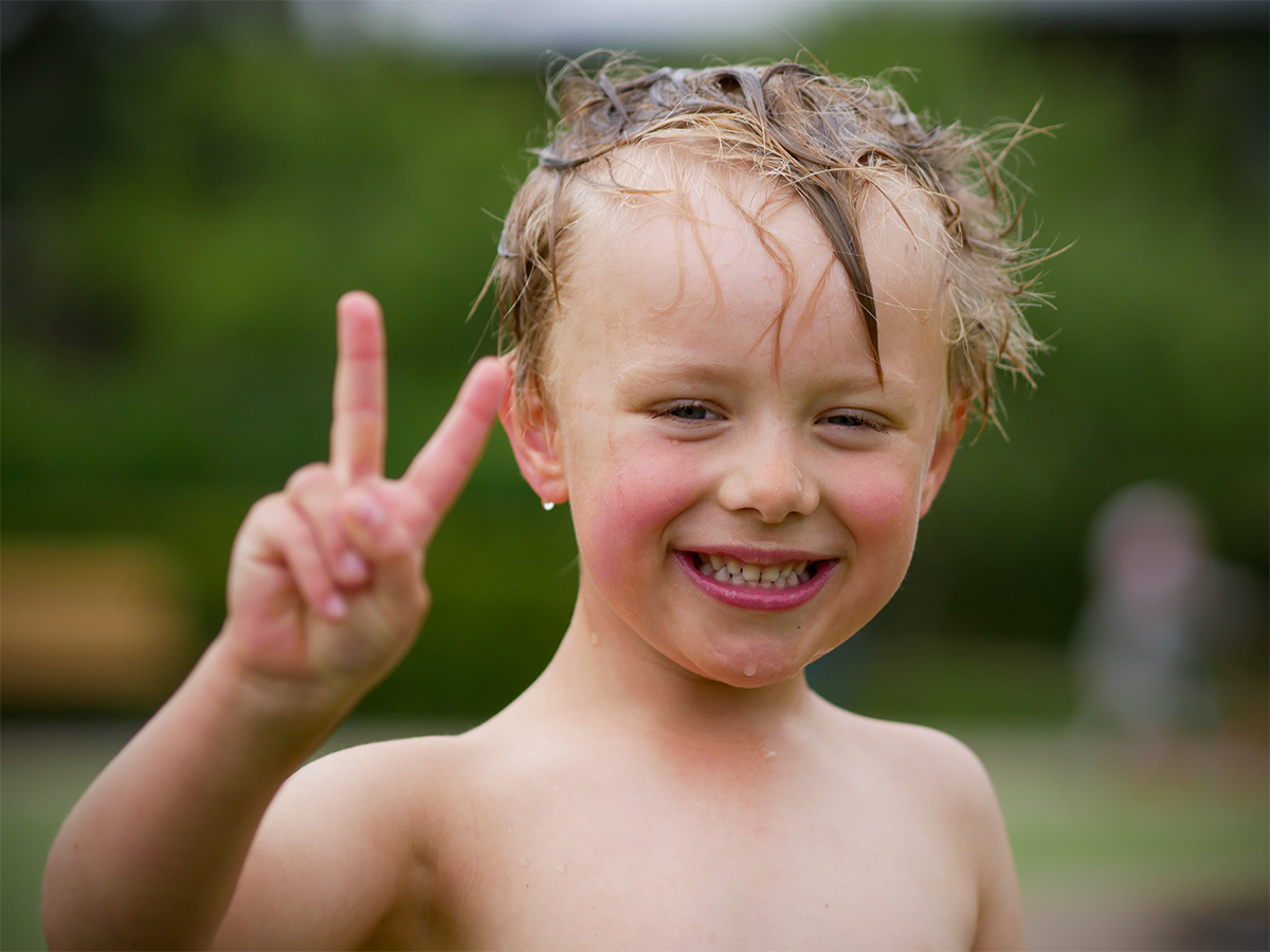 Folke, genomblöt men lycklig, gör V-tecknet mot kameran