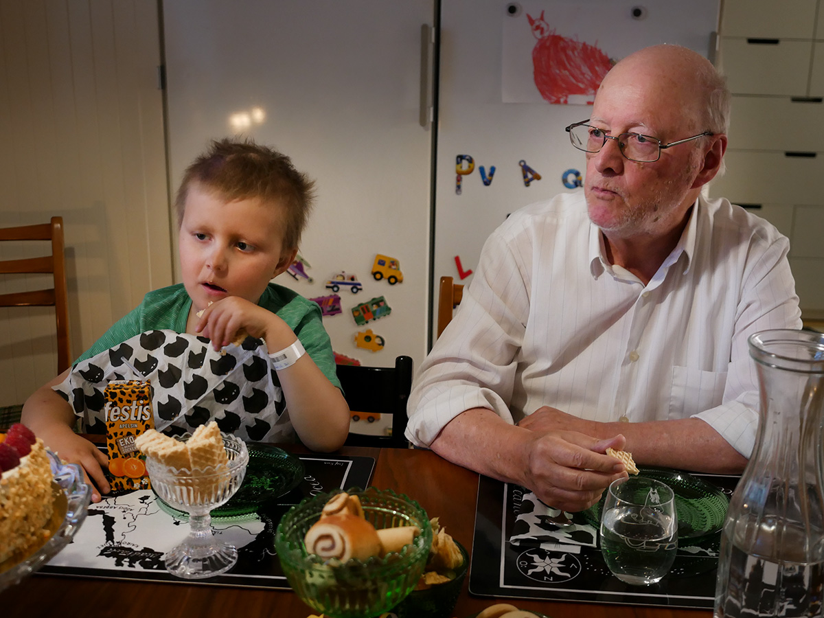 Elis och farfar vid köksbordet under Folkes födelsedagsfika.