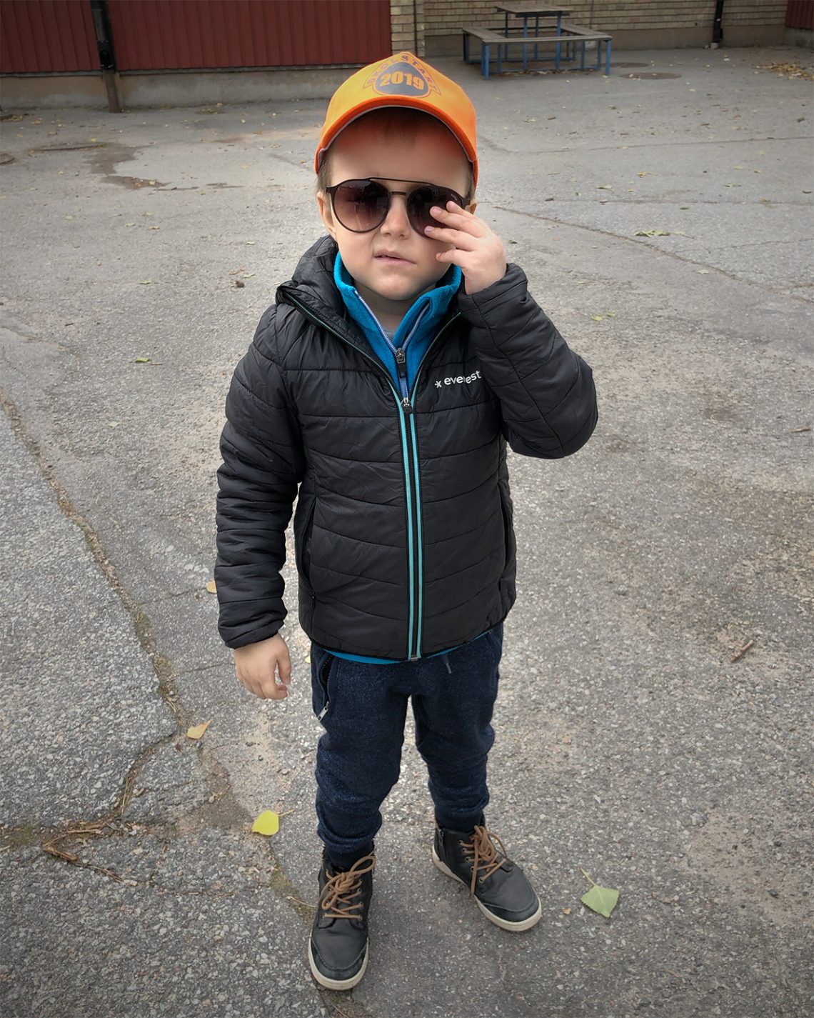 Elis på skolgården, med sin orangea skolstart-keps och pappas solglasögon