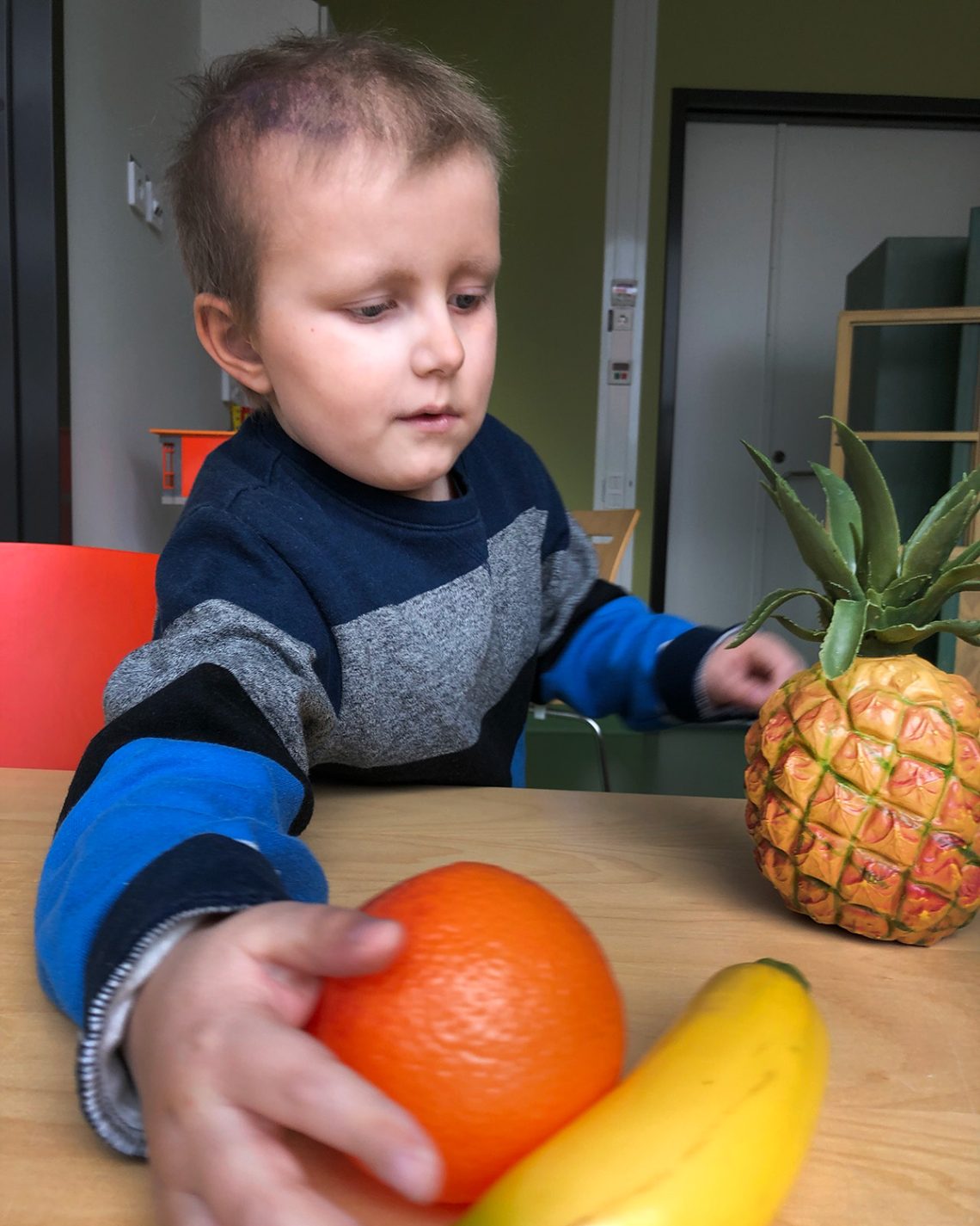 Elis leker med plastfrukter på lekterapin