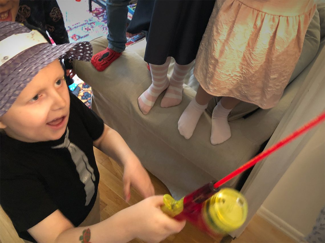 Elis kör fiskdamm på kalaset, iklädd en rolig damhatt