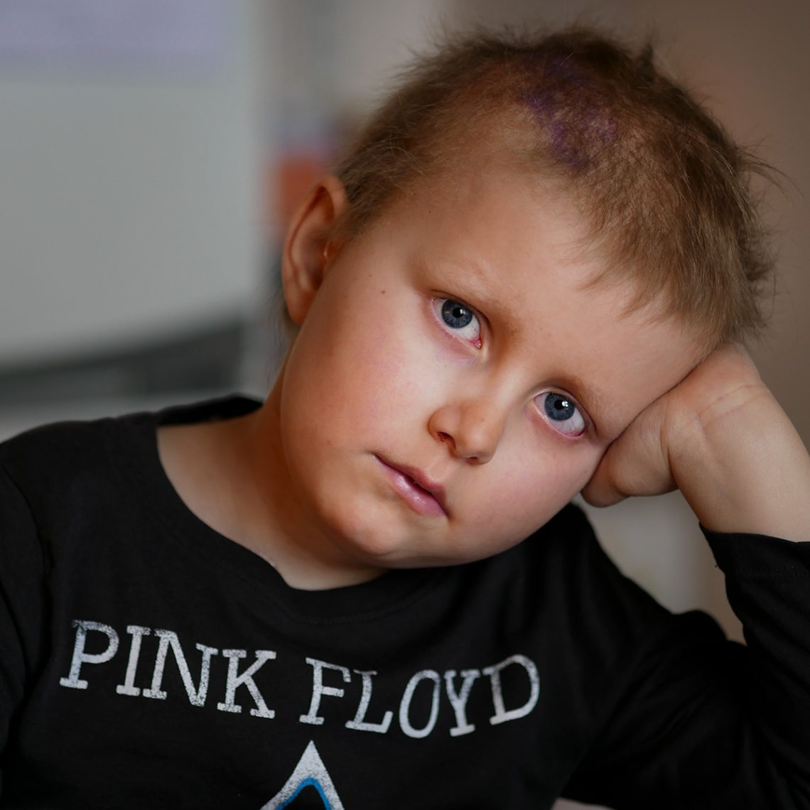 Elis lutar huvudet i handen och tittar in i kameran. Bilden är tagen hos farmor, den 29 september 2019