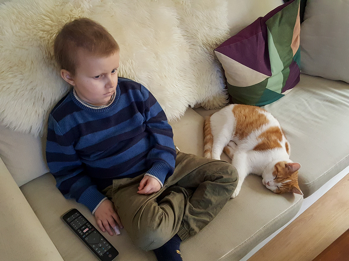 Elis och katten Sune vilar i soffan tillsammans efter mer än en timmes lek.