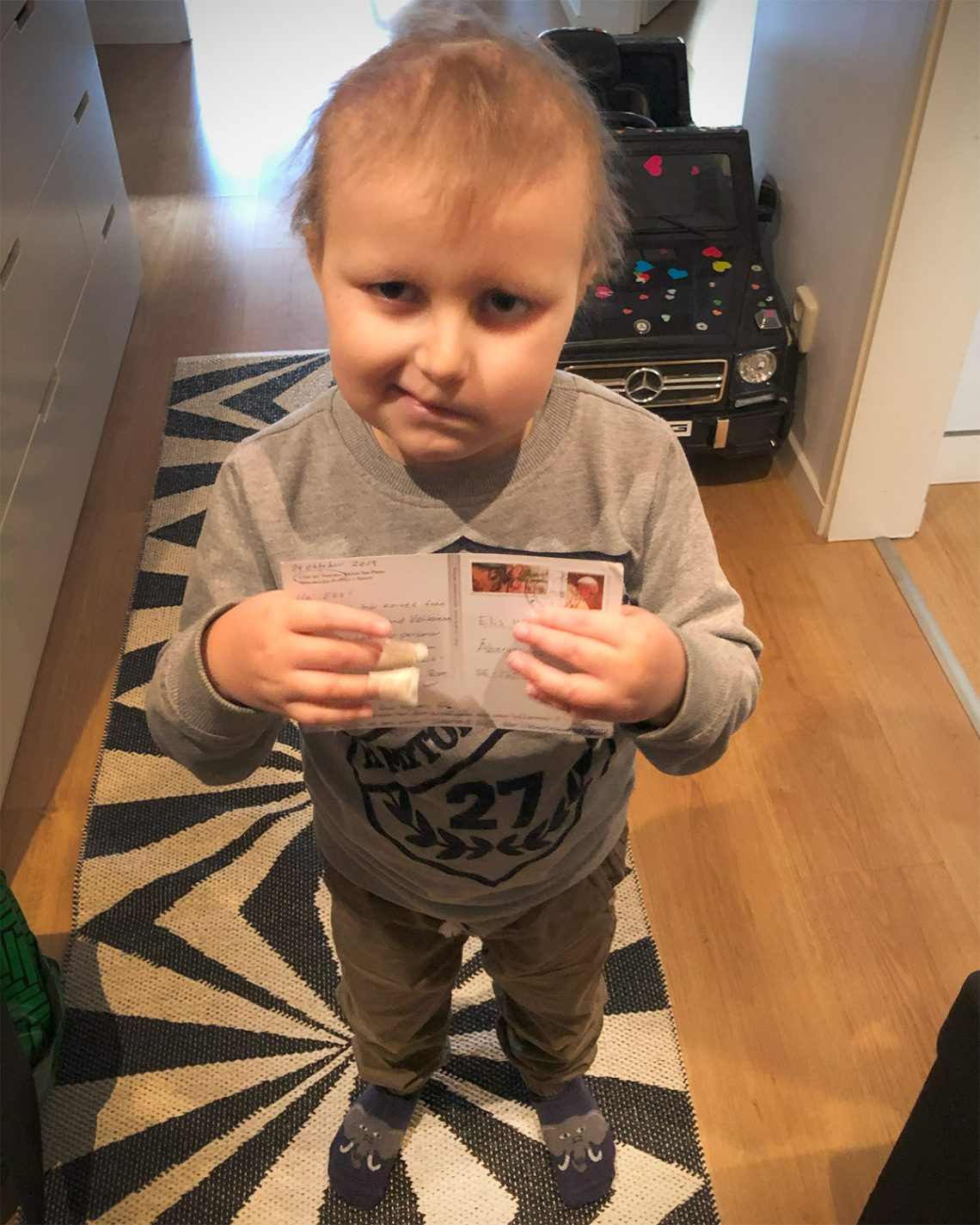 Elis håller upp ett vykort han fått från Tommy